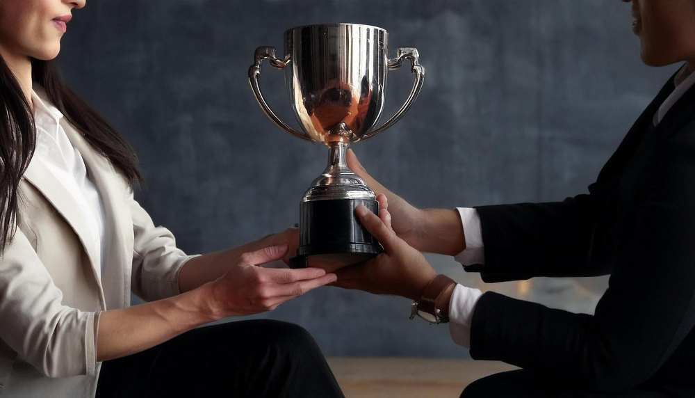 Duas pessoas segurando um trofeu